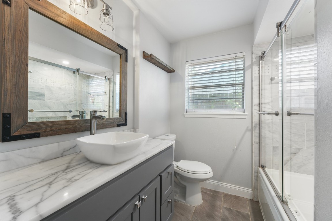 5907 Peg Street Houston, TX 77092 - Photo 17 of 21 a bathroom with a granite countertop sink toilet a mirror and shower