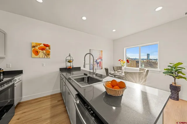 a kitchen with stainless steel appliances granite countertop a sink a stove and a refrigerator