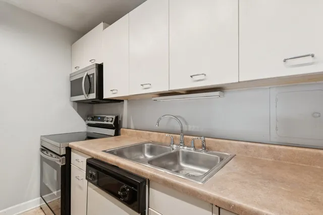 a kitchen with stainless steel appliances granite countertop a sink a stove and microwave