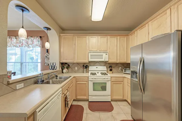 a kitchen that has a stove a sink and a refrigerator