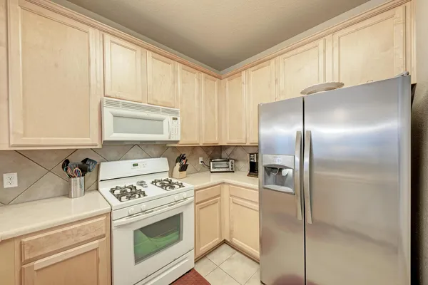 a kitchen with a refrigerator sink and cabinets