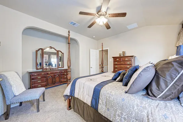 a bedroom with a bed a couch and dresser