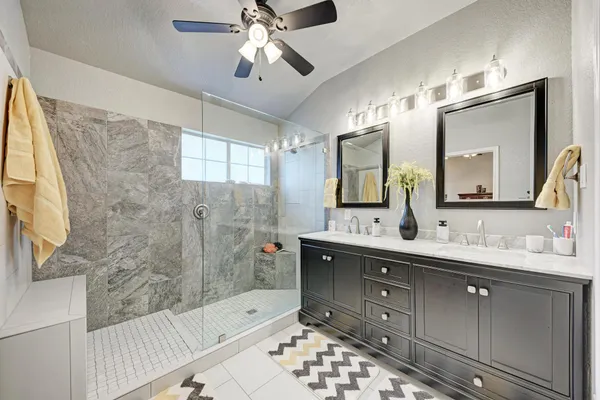 a bathroom with a double vanity sink mirror and bathtub