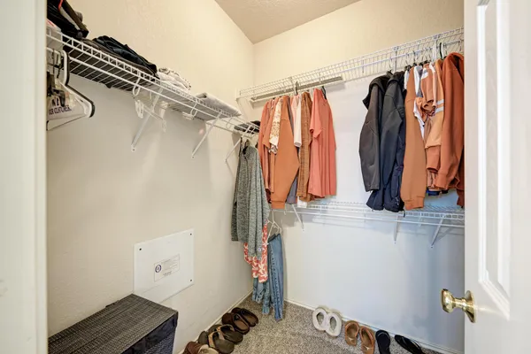 a view of walk in closet with clothes