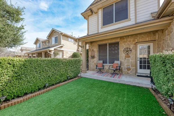 a view of a chair and table in backyard of the house