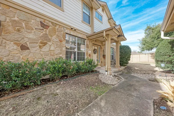 a view of a white house next to a yard