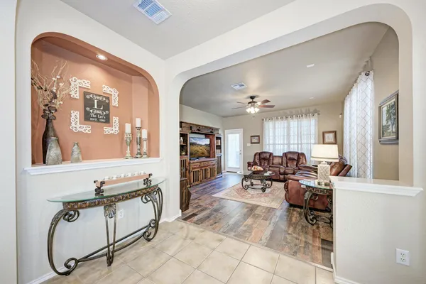 a living room with furniture a flat screen tv and gym equipment