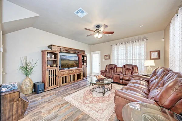 a living room with furniture a chandelier and a flat screen tv