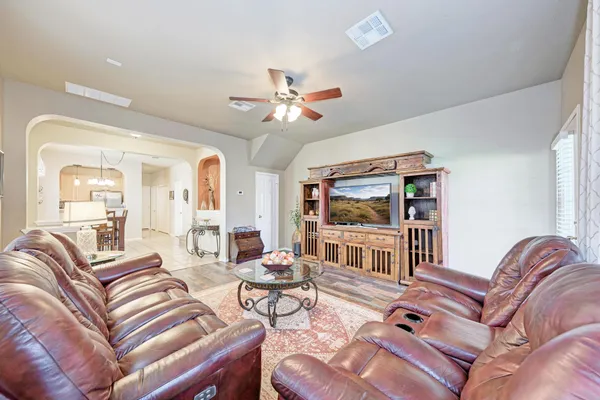 a living room with furniture a flat screen tv and a chandelier