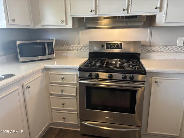a stove top oven sitting inside of a kitchen