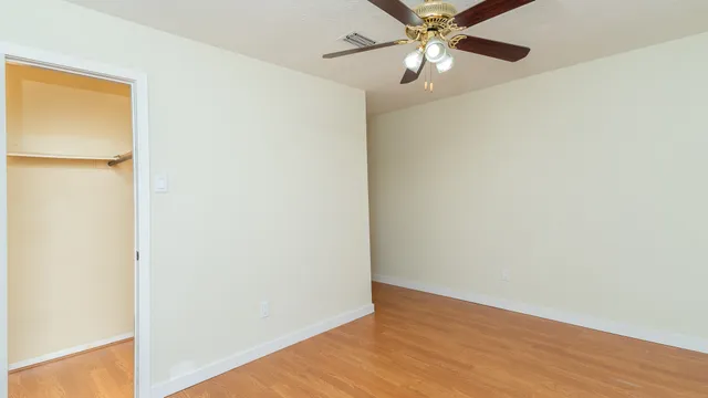 a view of an empty room with wooden floor