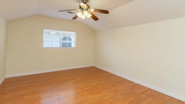 an empty room with a window and a ceiling fan