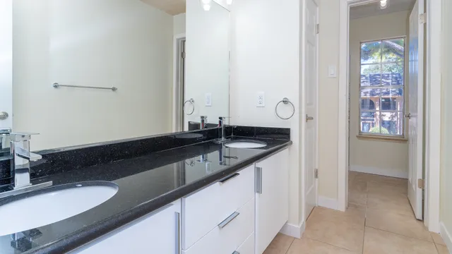 a bathroom with a granite countertop sink and a mirror