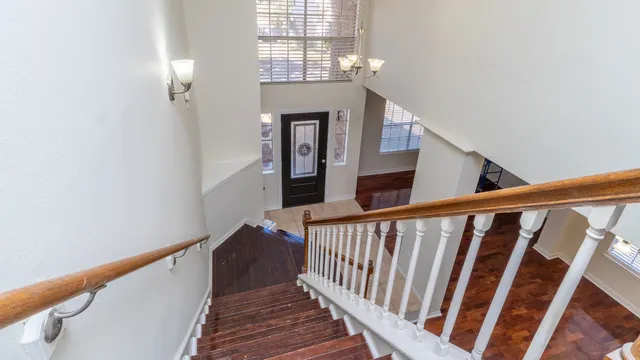 a view of staircase with railing and white walls