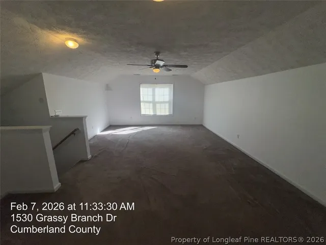 en empty room with windows and ceiling fan