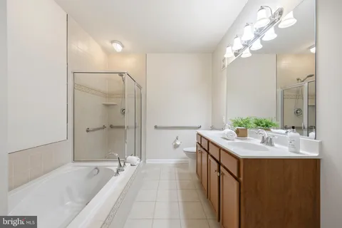 a spacious bathroom with a bathtub sink and mirror