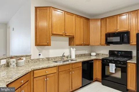 a kitchen with stainless steel appliances granite countertop white cabinets sink and a granite counter top