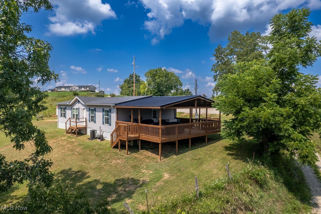 560 Wine Road Elizabeth, WV 26143 - Photo 35 of 50 Rear view of property with a wooden deck, a lawn, and a metal roof