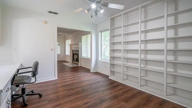 a view of a workspace with furniture and wooden floor