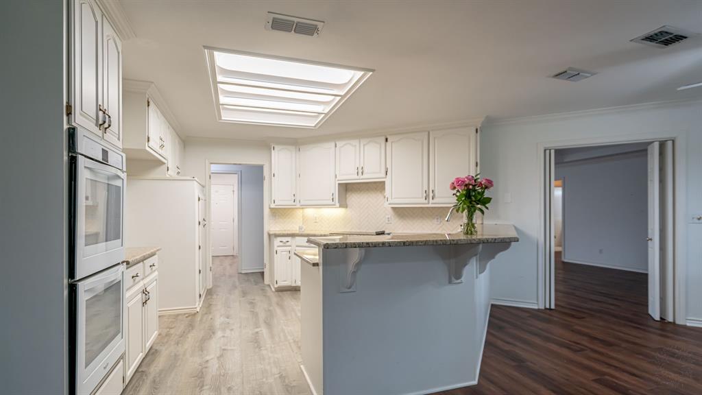 111 Scenic Drive Dublin, TX 76446 - Photo 5 of 40 a kitchen with cabinets and wooden floor