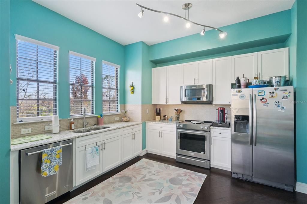 515 Mirasol Circle, Unit 302 Celebration, FL 34747 - Photo 14 of 60 a kitchen with stainless steel appliances a stove sink and refrigerator