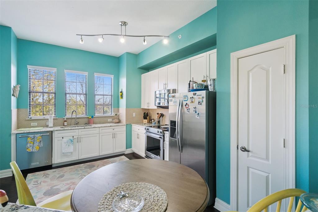 515 Mirasol Circle, Unit 302 Celebration, FL 34747 - Photo 19 of 60 a kitchen with stainless steel appliances granite countertop a refrigerator a stove and a sink with large window