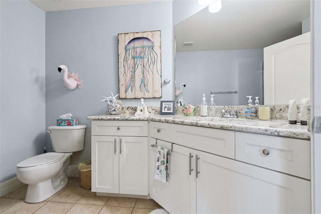 515 Mirasol Circle, Unit 302 Celebration, FL 34747 - Photo 33 of 60 a bathroom with a granite countertop toilet sink and mirror