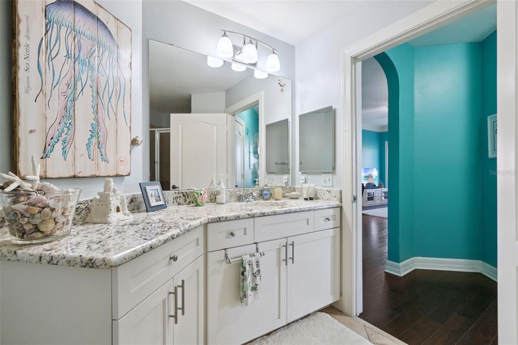 515 Mirasol Circle, Unit 302 Celebration, FL 34747 - Photo 37 of 60 a bathroom with a granite countertop sink and a mirror