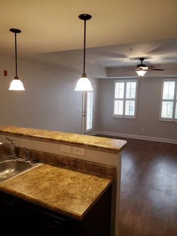 a kitchen with a sink chandelier and wooden floor