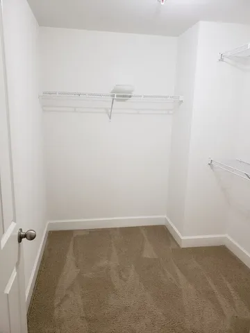 a view of a big room with wooden floor and windows