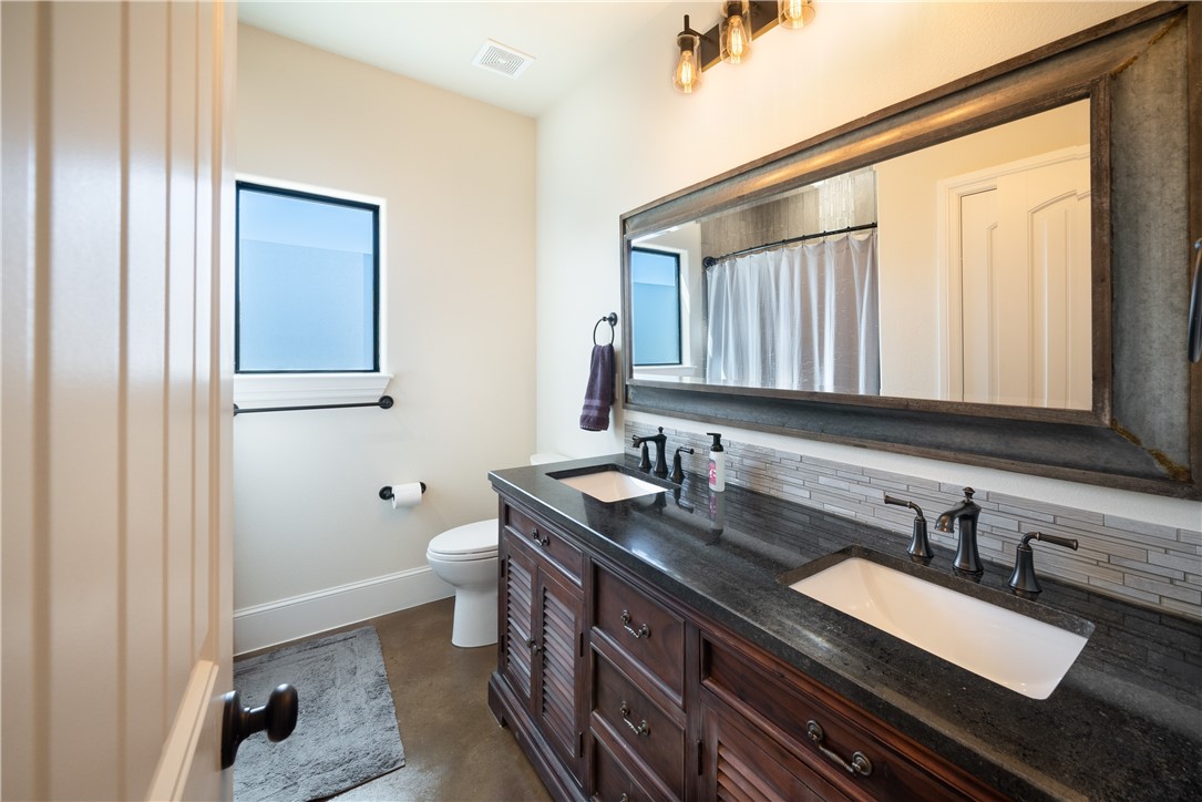 315 Bluestem Cove Georgetown, TX 78633 - Photo 25 of 35 a bathroom with a granite countertop sink a toilet and a mirror