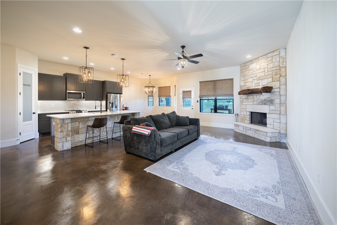 315 Bluestem Cove Georgetown, TX 78633 - Photo 3 of 35 a living room with stainless steel appliances kitchen island a large kitchen island a stove a sink dishwasher a oven with white cabinets and wooden floor