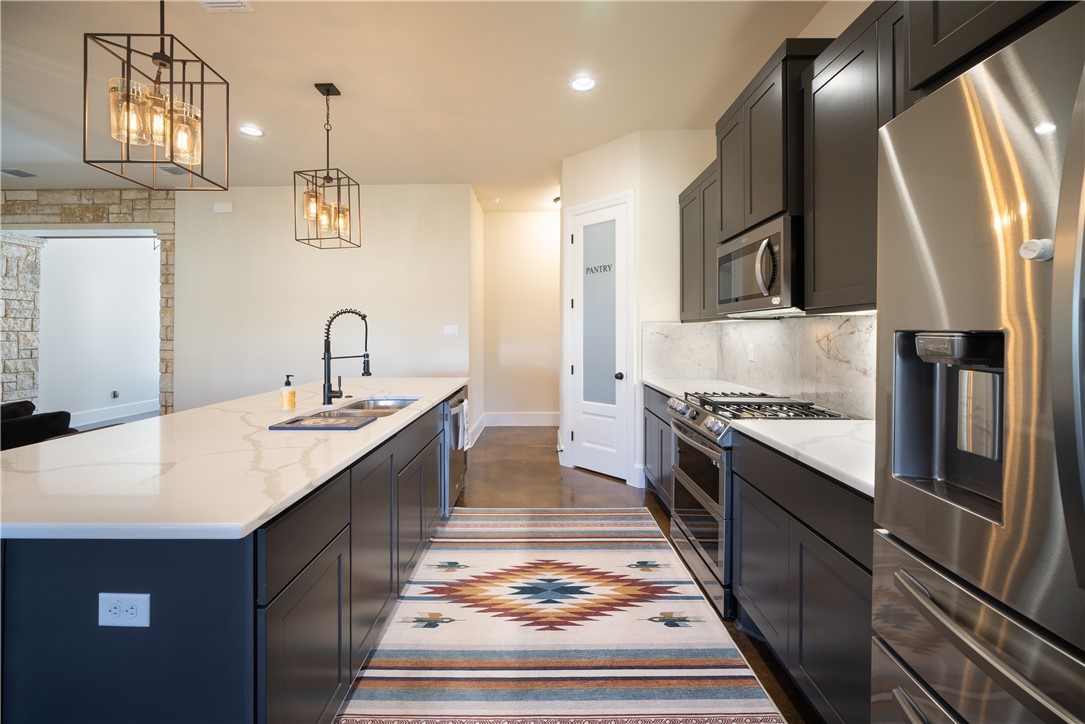315 Bluestem Cove Georgetown, TX 78633 - Photo 7 of 35 a kitchen with stainless steel appliances granite countertop a sink and stove