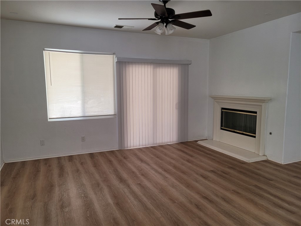 25540 Turfwood Street Menifee, CA 92585 - Photo 5 of 27 a view of an empty room with wooden floor and a window