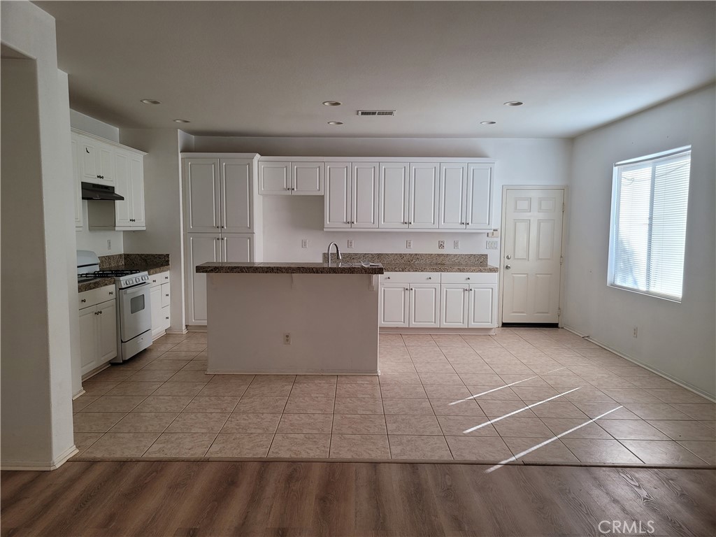25540 Turfwood Street Menifee, CA 92585 - Photo 6 of 27 a kitchen with stainless steel appliances a sink a stove a refrigerator and cabinets