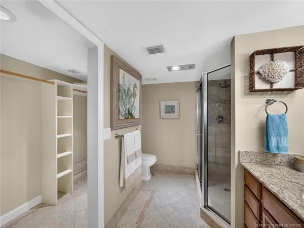 a bathroom with a granite countertop sink a toilet and shower