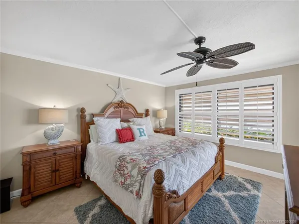 a bedroom with a bed a chandelier and a window
