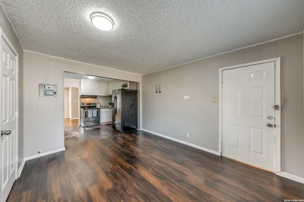 an empty room with wooden floor and a cabinet