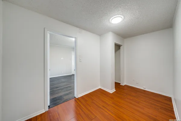 a view of empty room with wooden floor
