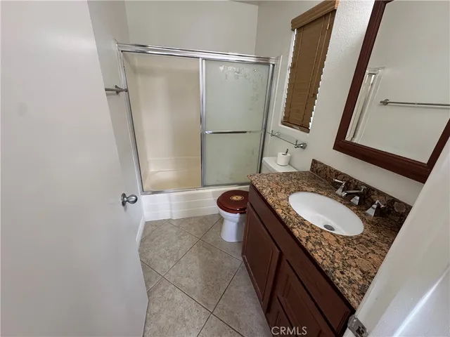 a bathroom with a sink a toilet a mirror and shower curtain