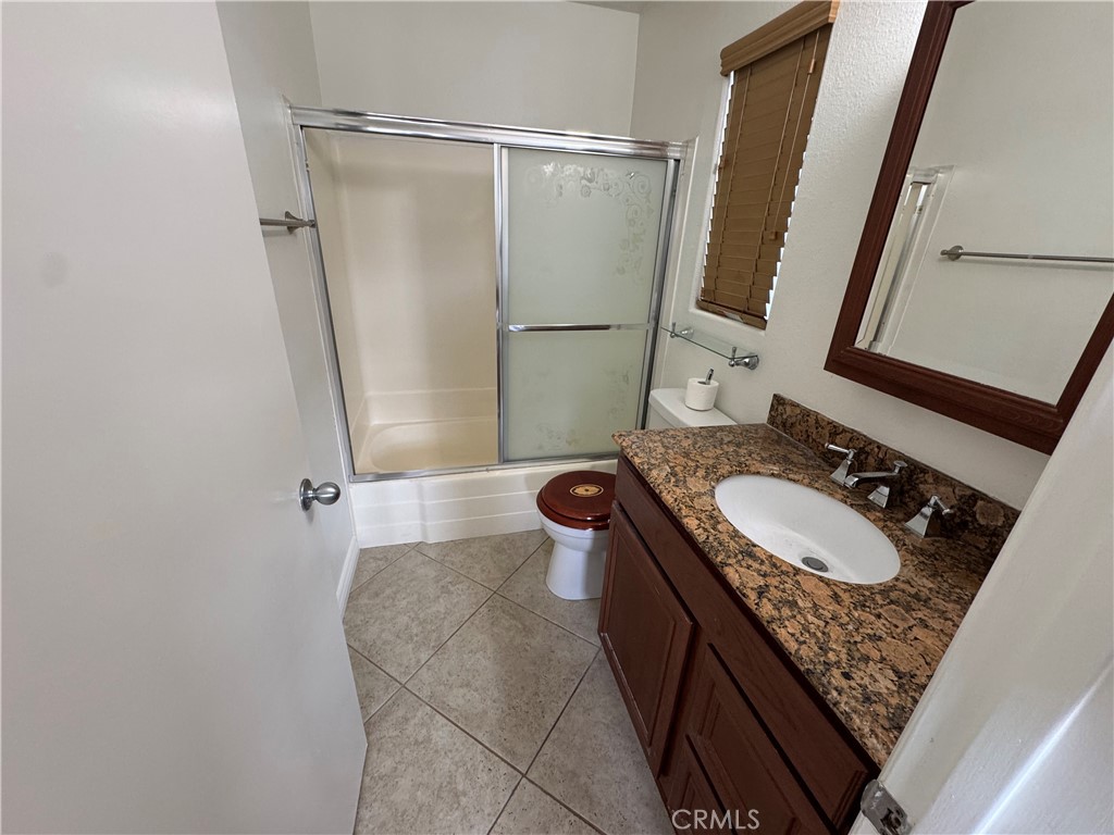 33966 Malaga Drive, Unit B Dana Point, CA 92629 - Photo 13 of 25 a bathroom with a sink a toilet a mirror and shower curtain