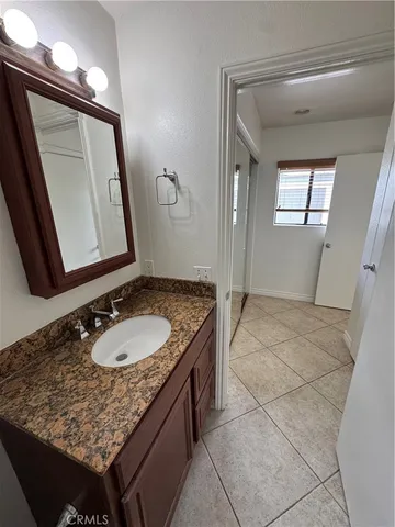 a bathroom with a granite countertop sink a mirror and vanity