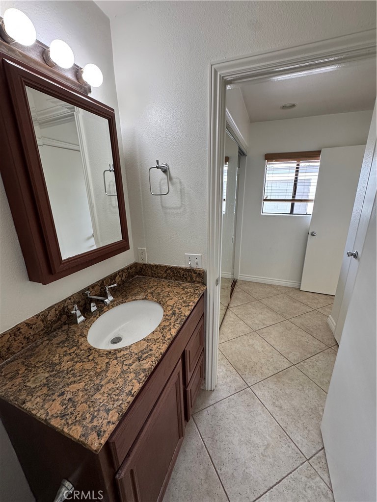 33966 Malaga Drive, Unit B Dana Point, CA 92629 - Photo 14 of 25 a bathroom with a granite countertop sink a mirror and vanity