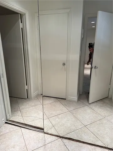 a view of a refrigerator in kitchen and an empty room