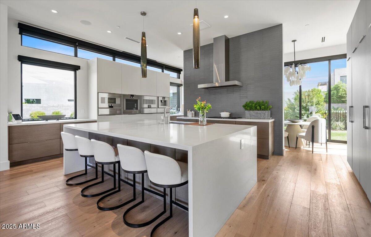 6802 East Joshua Tree Lane Paradise Valley, AZ 85253 - Photo 12 of 70 a kitchen with stainless steel appliances granite countertop a stove a refrigerator a kitchen island a dining table and chairs with wooden floor