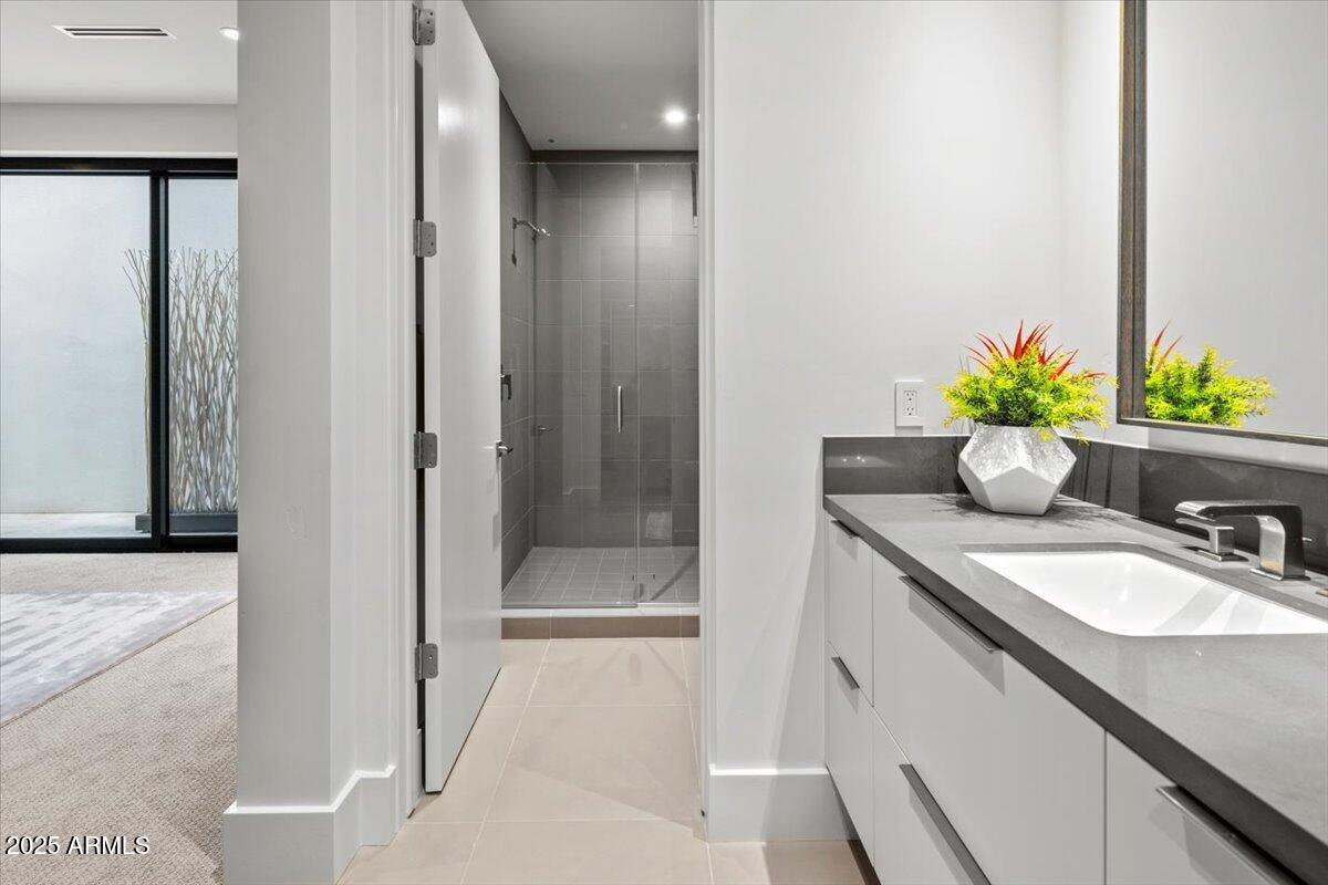6802 East Joshua Tree Lane Paradise Valley, AZ 85253 - Photo 40 of 70 a bathroom with a granite countertop sink a mirror and a shower