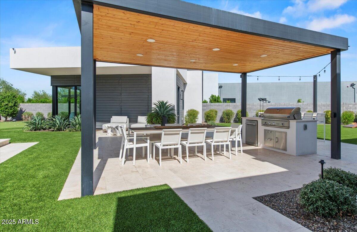 6802 East Joshua Tree Lane Paradise Valley, AZ 85253 - Photo 56 of 70 a view of a patio with table and chairs potted plants and palm tree