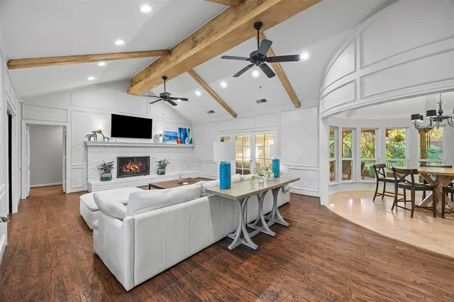 a view of a livingroom with furniture a ceiling fan and wooden floor