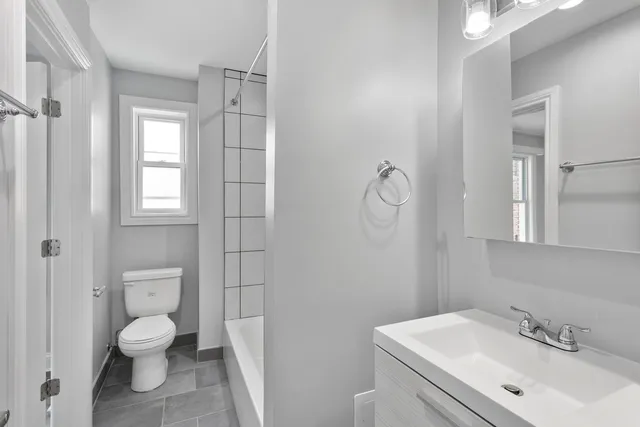 a bathroom with a toilet a sink and mirror