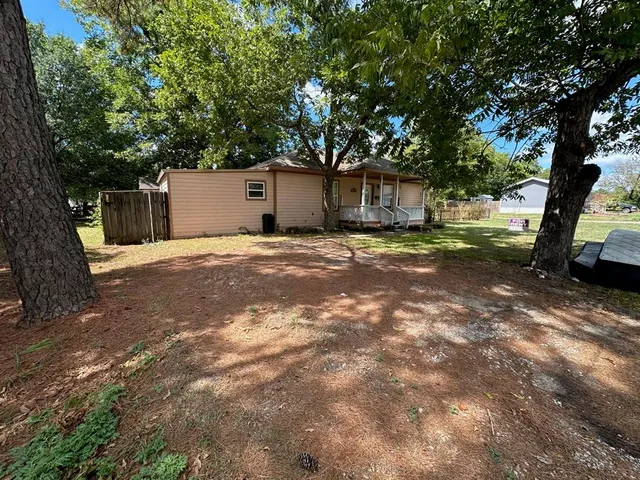 a backyard of a house with yard and tree